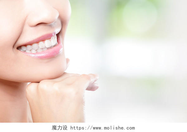 美丽的年轻女子的牙齿与右侧的副本空间密切孤立在绿色背景亚洲美女模特牙齿美白
